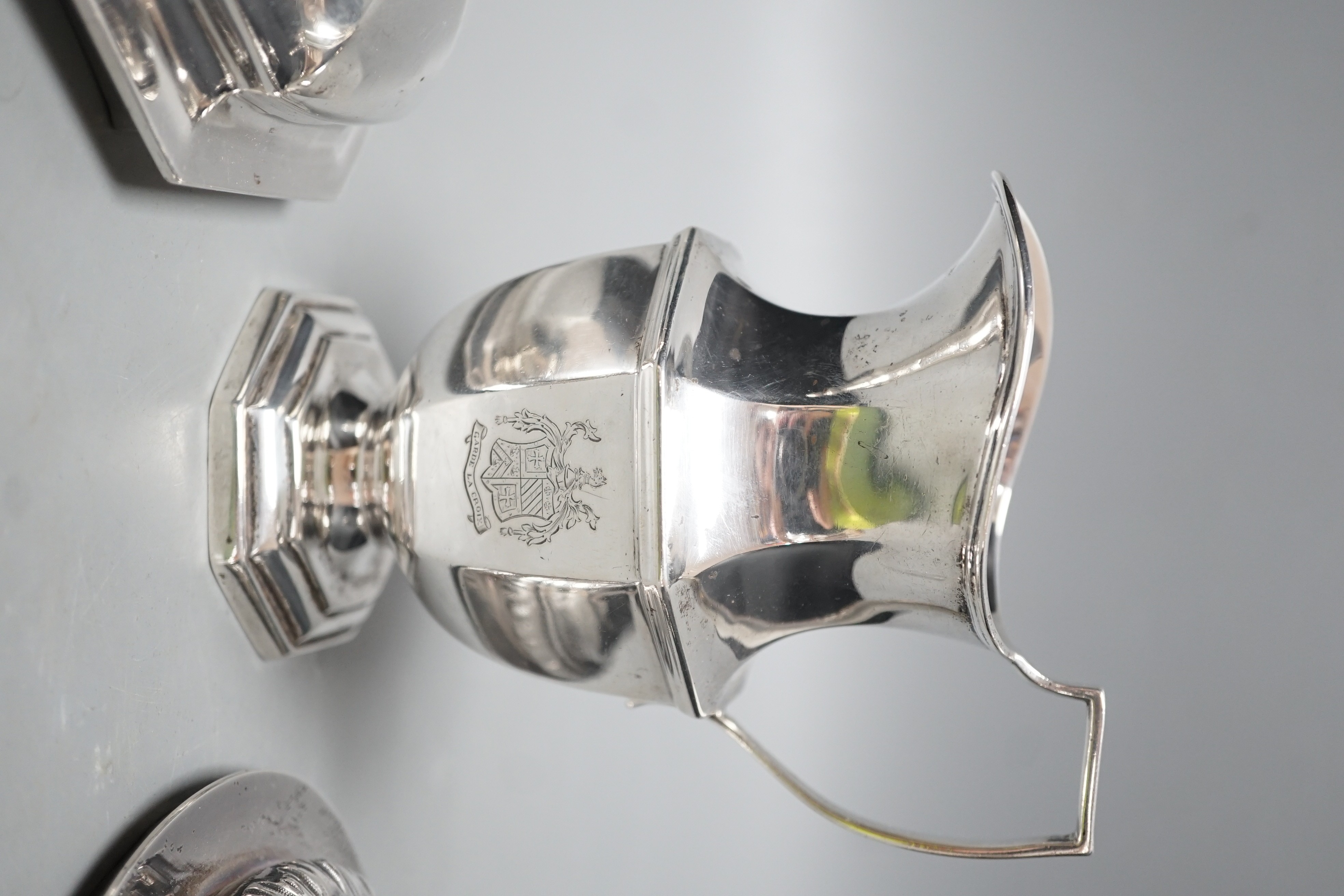 A 20th century silver cream jug by Mappin & Webb(date letter rubbed), height 13.9cm and two Victorian trophy cup covers, one with sheep finial, 24.8oz.